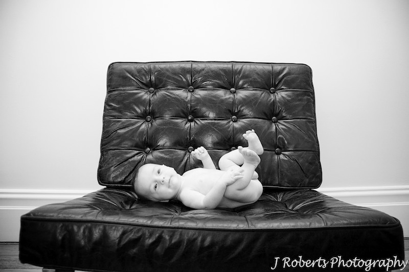 Naked baby boy on leather couch - baby portrait photography sydney